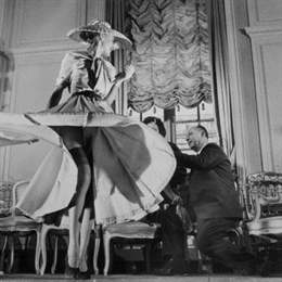 11 Mar 1948, Paris, France --- Stockings were highlighted for the first time when Christian Dior (right), noted French designer, exhibited his French collection. The hose, which either continued the dress' color scheme from hem to ankles or afforded a direct contrast, ranged in shades from tender peach to ink black. The colors are called "Boulevard Banquet." Here a model swirls the skirt of a light blue crepe dress to feature the sheer navy blue stockings. --- Image by © Bettmann/CORBIS